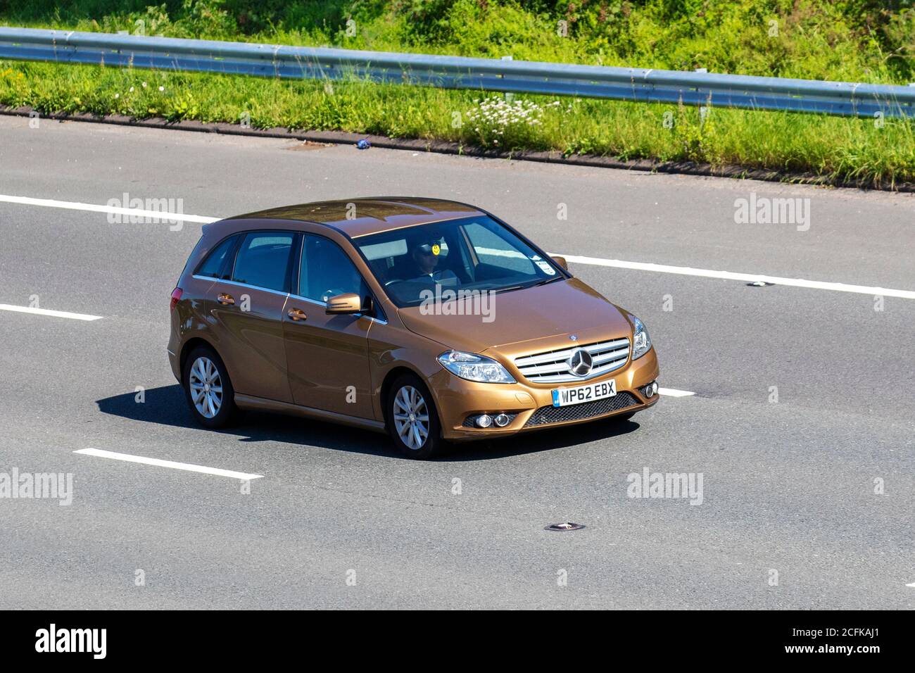 2012 beige Mercedes-Benz B180 Blueefficiency SE CD; Vehicular traffic moving vehicles, cars driving vehicle on UK roads, motors, motoring on the M6 motorway highway network. Stock Photo