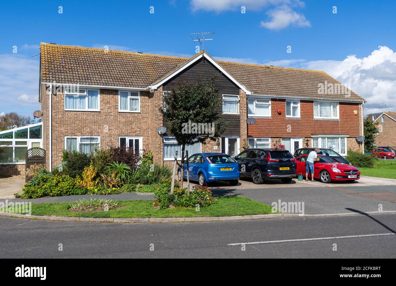 Small modern terrace 2-storey British houses in a small town with cars in driveway (off-road parking) in West Sussex, England, UK. Stock Photo