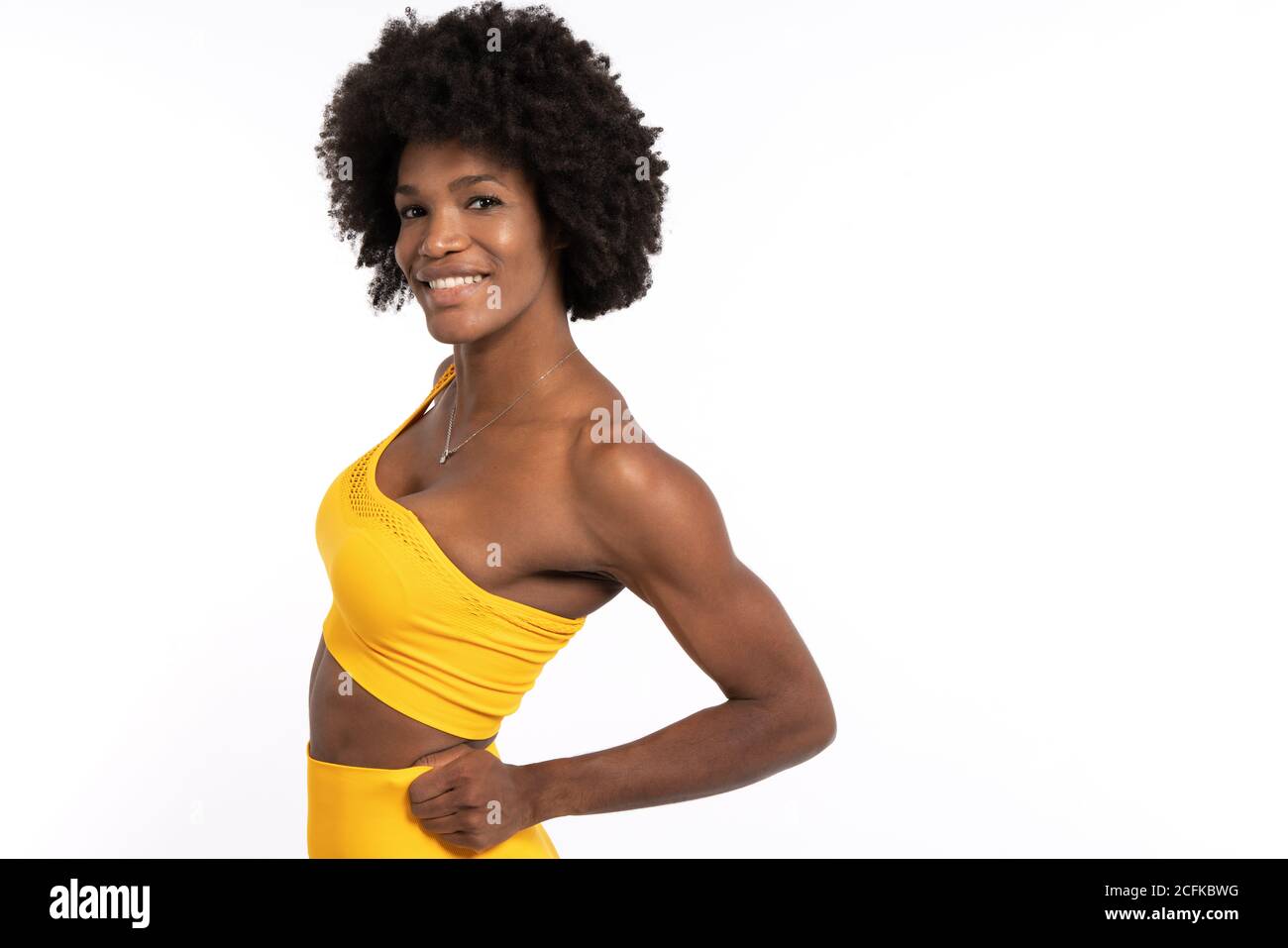 https://c8.alamy.com/comp/2CFKBWG/black-female-in-yellow-sportswear-posing-and-looking-away-against-gray-background-2CFKBWG.jpg