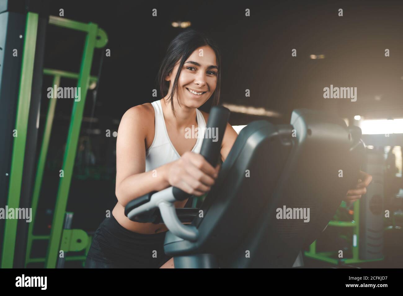 Fitness girl is engaged on a stationary bike. Pretty young woman loses weight  in the gym Stock Photo