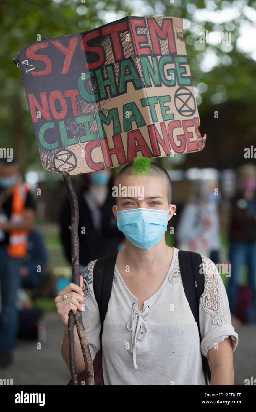 London, UK. 06th Sep, 2020. Extinction Rebellion hold a Flood Alert beach party to highlight the threat of rising tides and the risk of widespread flooding at Oxo Tower Wharf, London, 6th September 2020. A young female protestor holds a placard with system change not climate change Credit: Denise Laura Baker/Alamy Live News Stock Photo