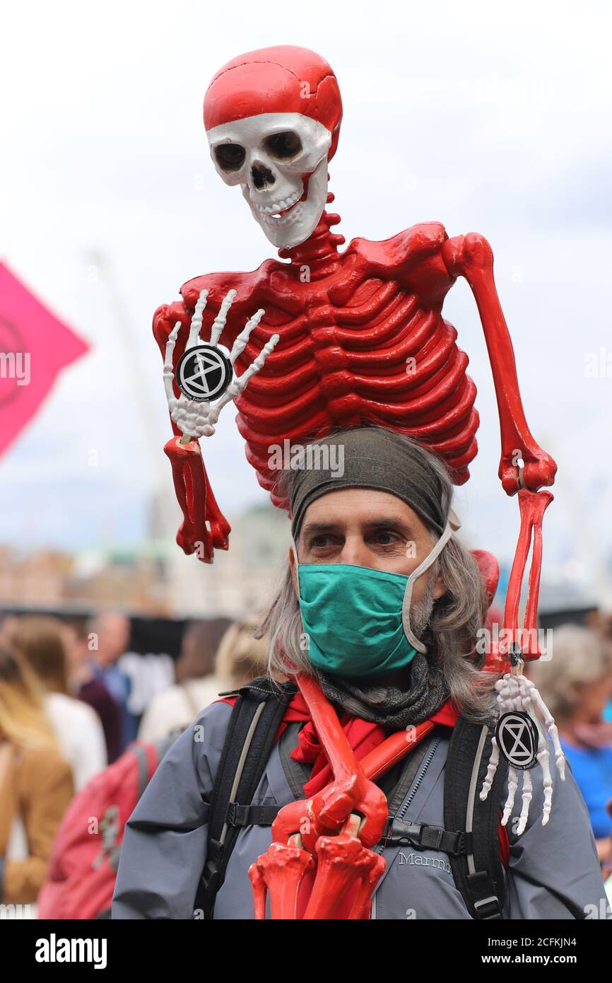 London, UK. 06th Sep, 2020. Extinction Rebellion hold a Flood Alert beach party to highlight the threat of rising tides and the risk of widespread flooding at Oxo Tower Wharf, London, 6th September 2020. A male protestor wears a red skeleton with an Extinction Rebellion symbol Credit: Denise Laura Baker/Alamy Live News Stock Photo