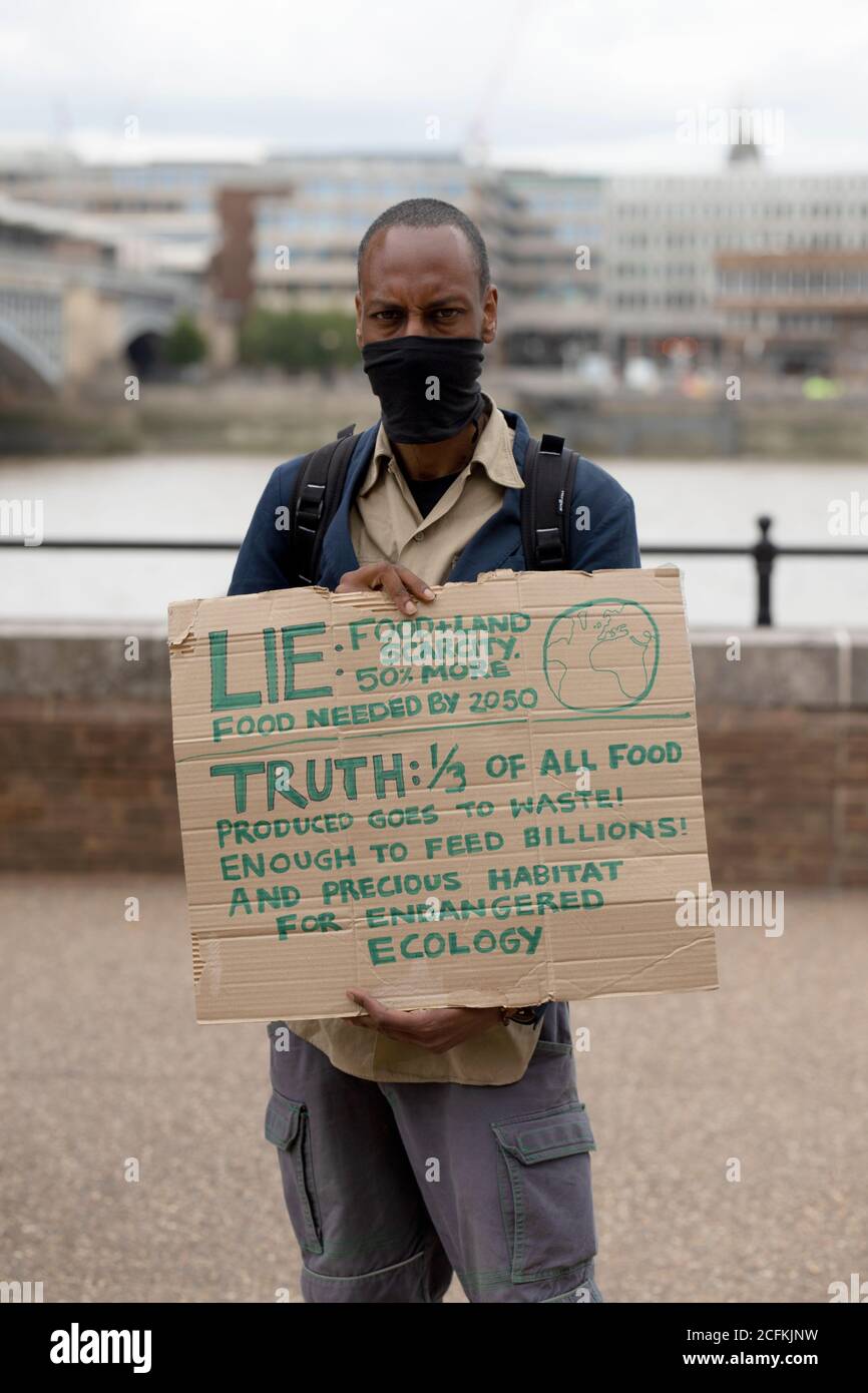 London, UK. 06th Sep, 2020. Extinction Rebellion hold a Flood Alert beach party to highlight the threat of rising tides and the risk of widespread flooding at Oxo Tower Wharf, London, 6th September 2020. A black male protestor holds a placard highlighting wasted food Credit: Denise Laura Baker/Alamy Live News Stock Photo