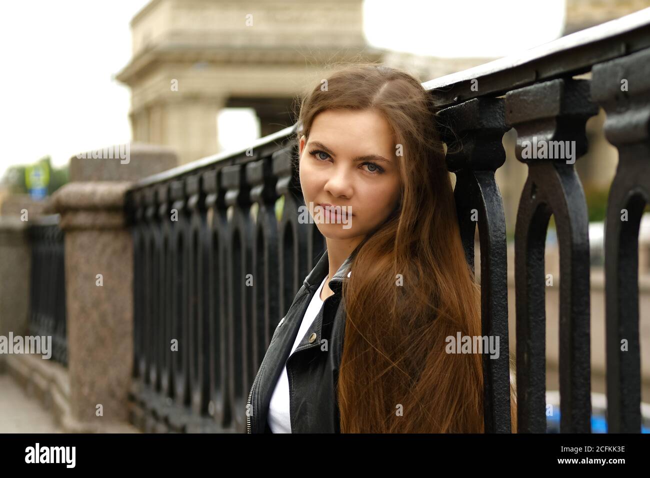 Young woman with long hair walking along the street of a big city. Saint Petersburg, Russia. Stock Photo