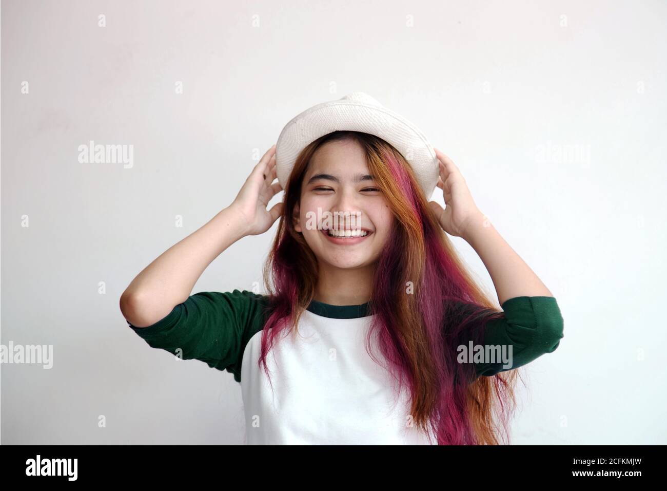 pretty asian femele smiling joyfully with colorful hair in dressed casually like hipster lifestyle, hair fashion concept. Stock Photo