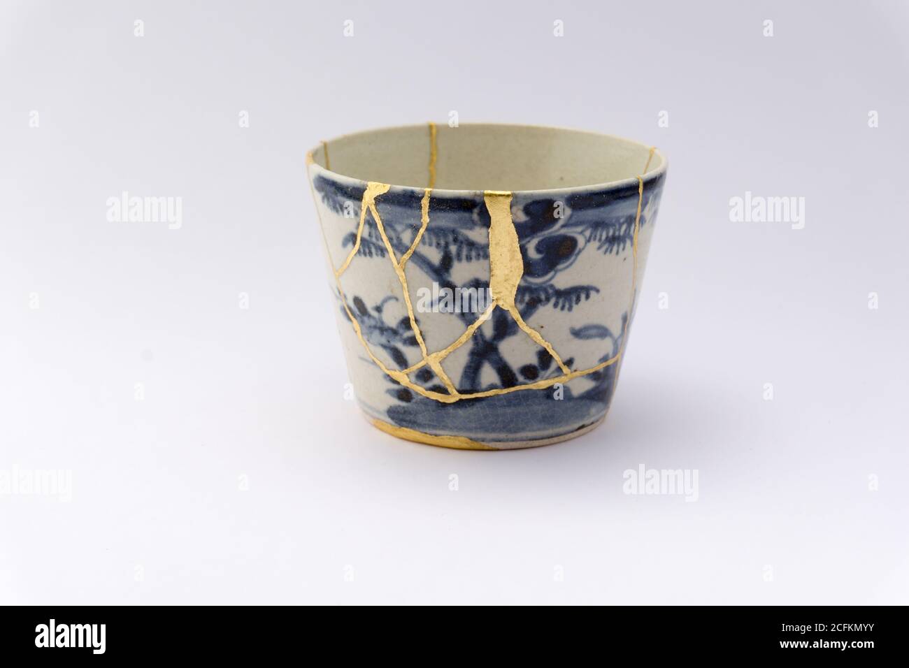 Kintsugi white and blue soba cup. Gold cracks restoration on old