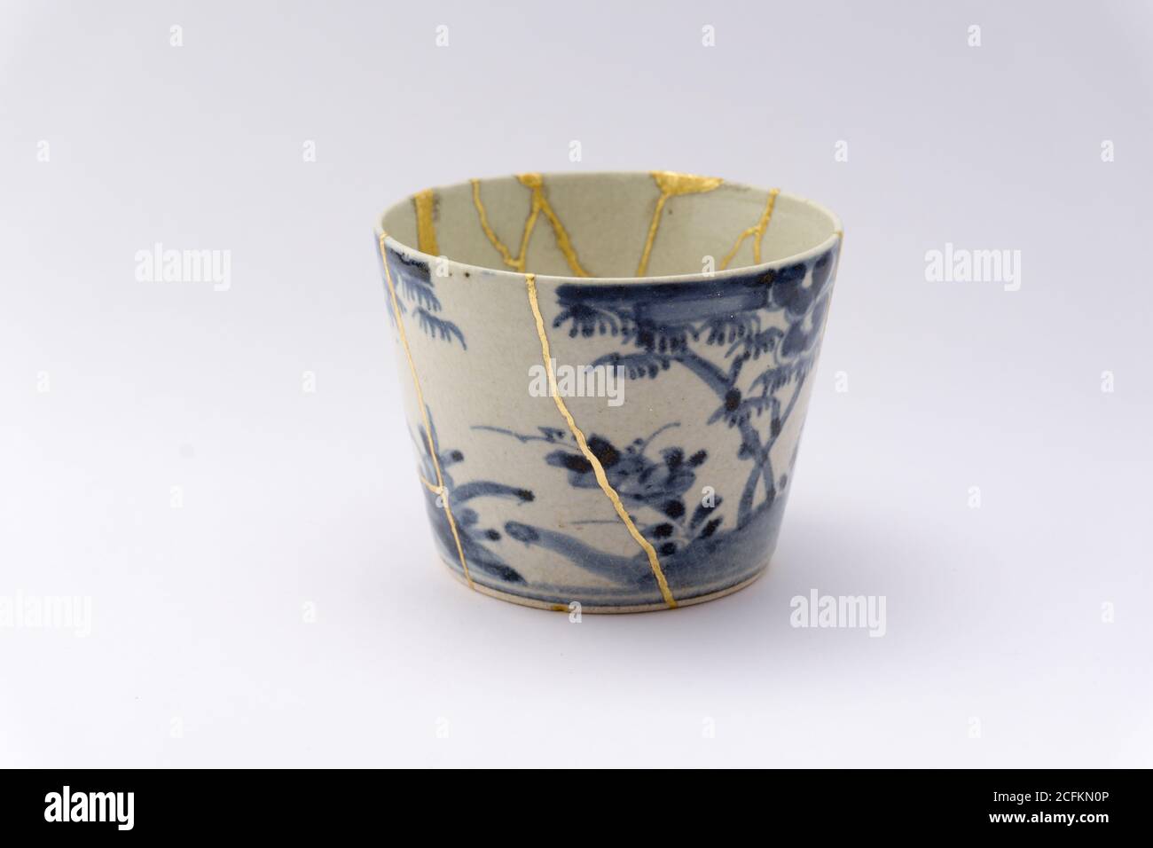 Kintsugi white and blue soba cup. Gold cracks restoration on old