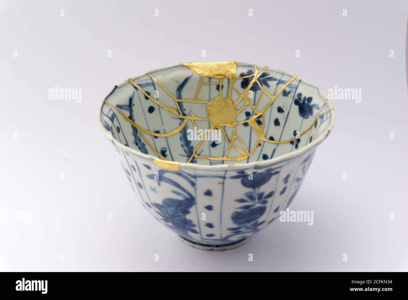 Kintsugi tea bowl ceremony chawan. Gold cracks restoration on old