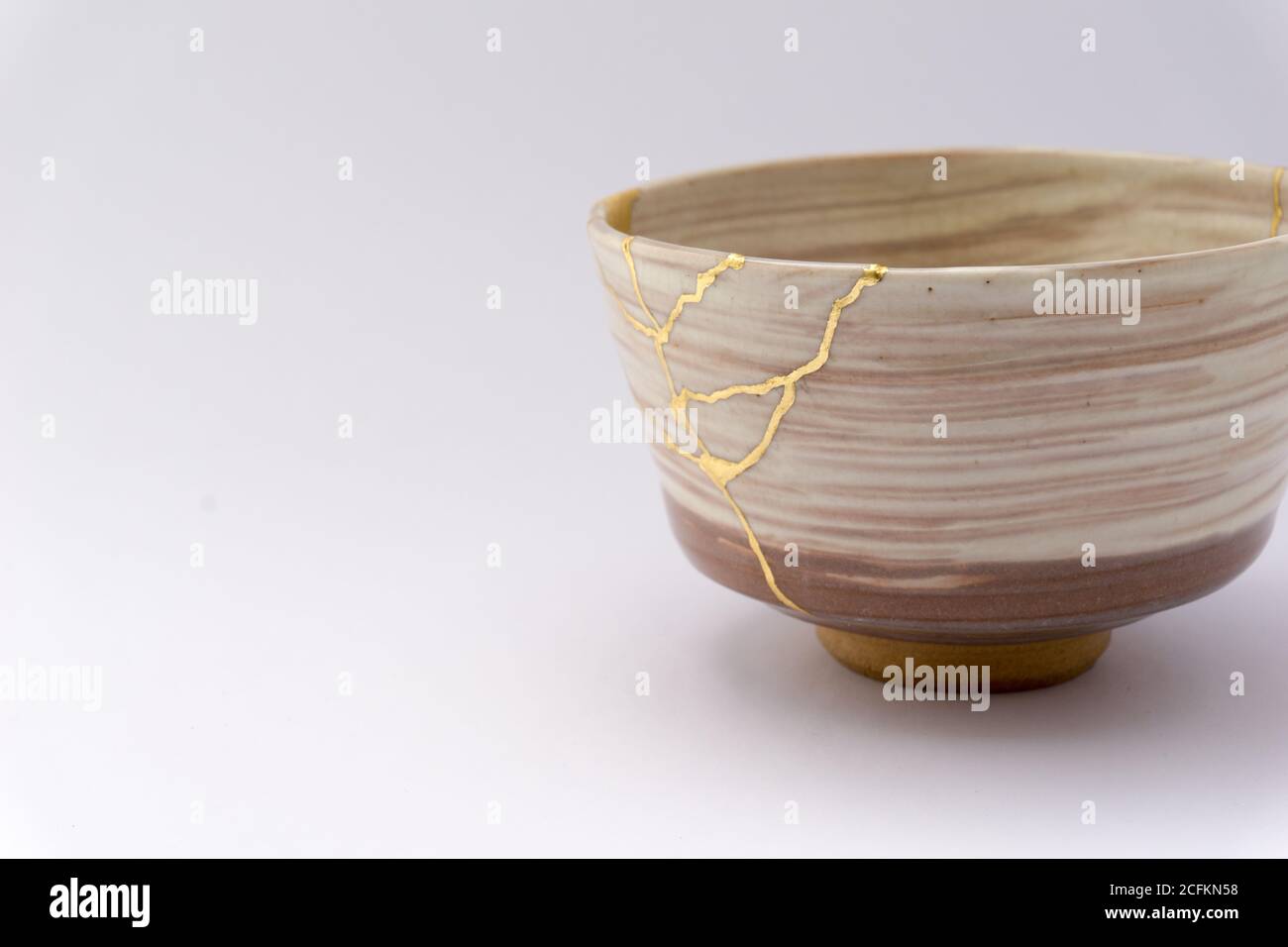 Kintsugi beige tea ceremony bowl. Gold cracks restoration on old ...