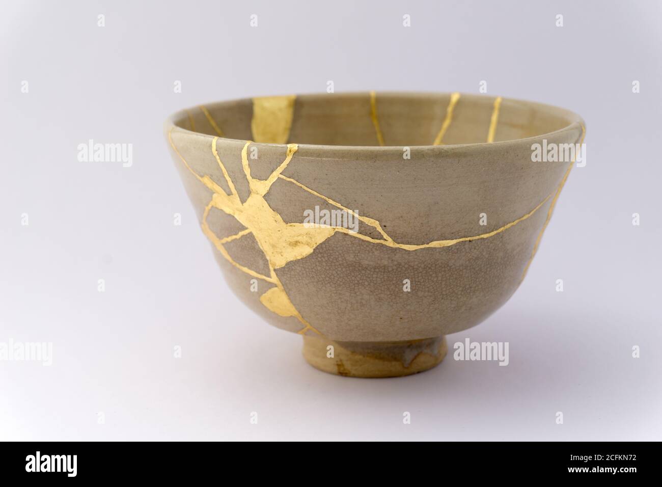 Kintsugi beige tea ceremony bowl. Gold cracks restoration on old ...