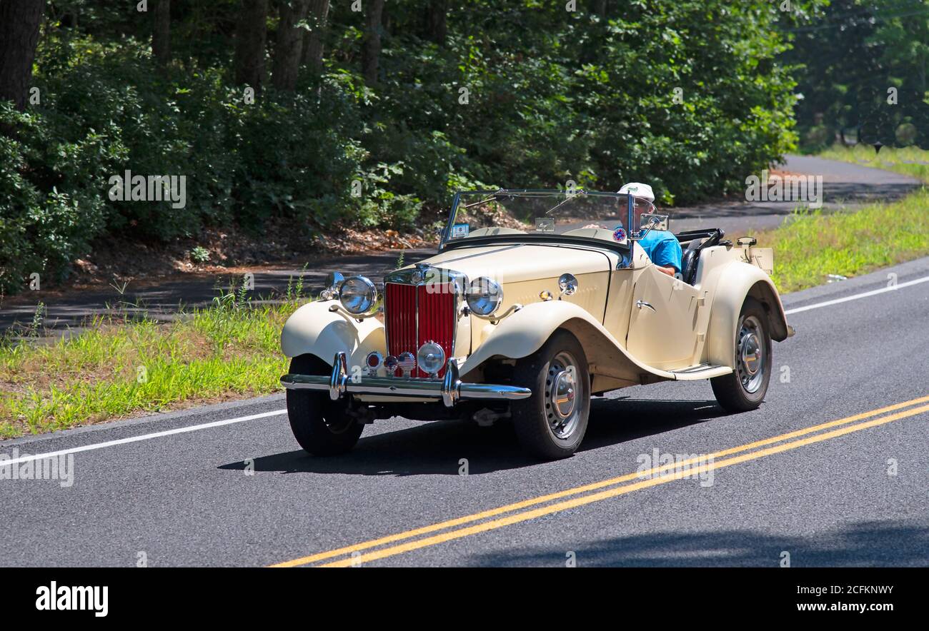 An MG roadster headed down a Cape Cod road. Stock Photo