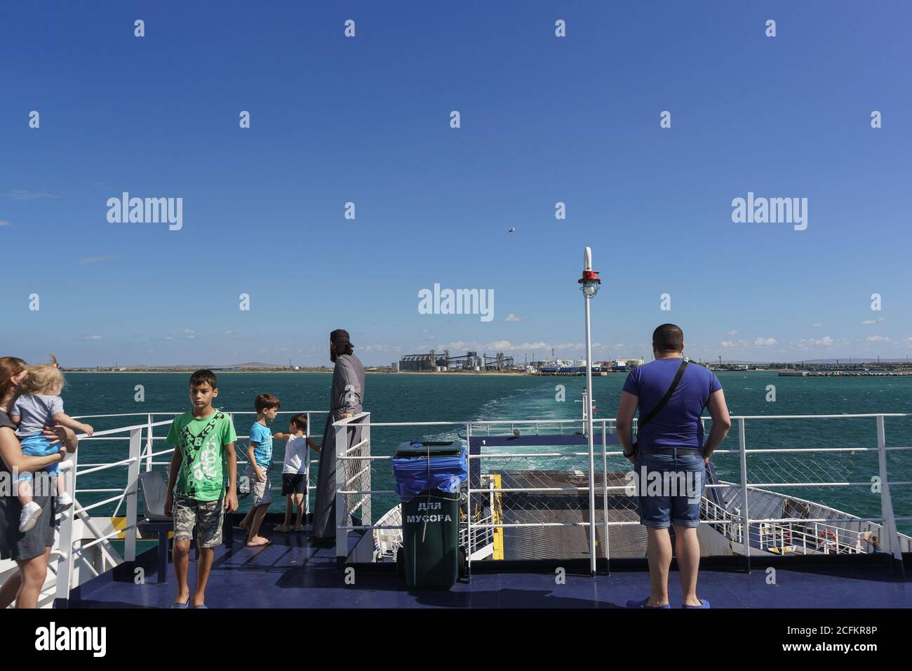 Russia, the Kerch Strait - September 02.2017: Passengers of the ferry 'Major Capiche' look at the receding coast of Caucasus port on the spit the Pig Stock Photo