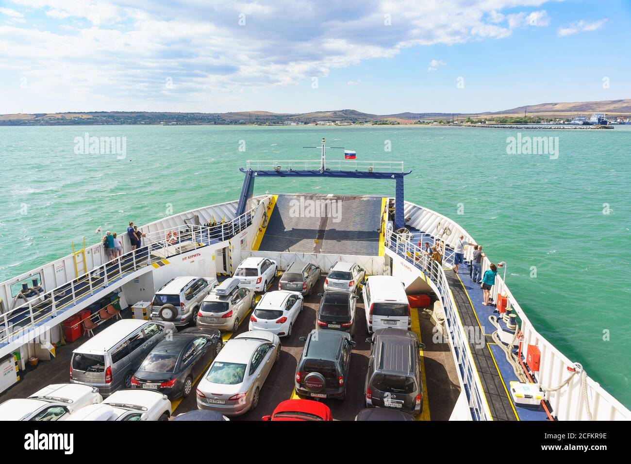 Russia, the Kerch Strait - September 02.2017: Loaded car deck of the ferry 'Major Capiche'. On the horizon, approaching the shore of the port of Crime Stock Photo