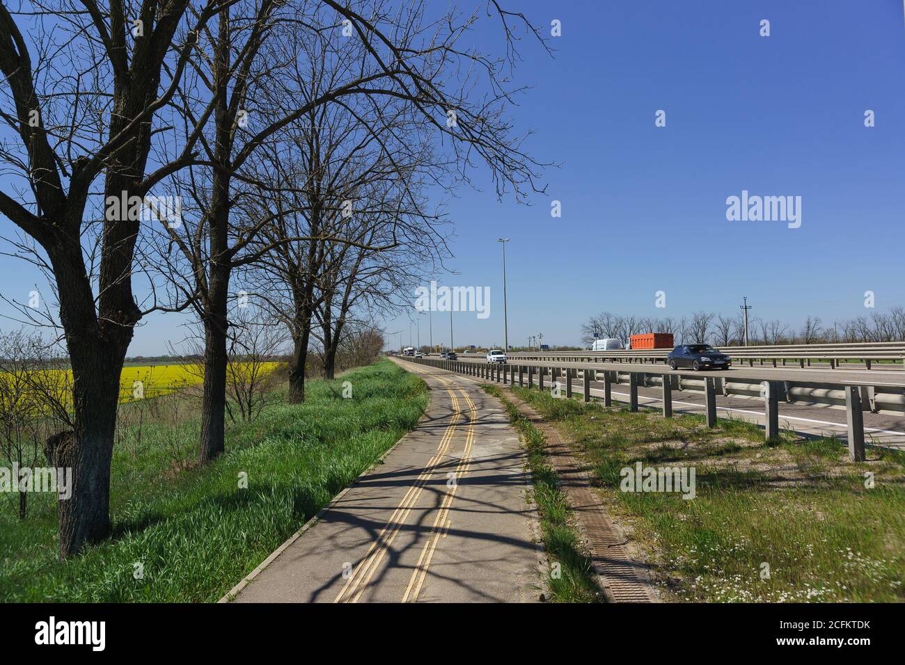 Russia, Krasnodar region - April 15.2018: Country road cycle path on the side. The Surrounding Area Of Krasnodar Stock Photo