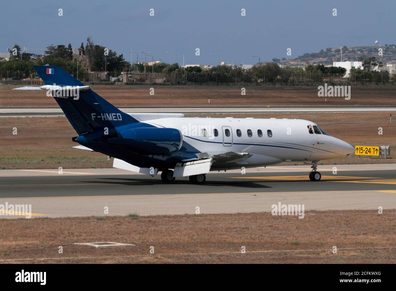 British Aerospace 125-1000 (Raytheon Hawker 1000) business jet taxiing on arrival in Malta, with pilot waving from cockpit window. VIP air travel. Stock Photo