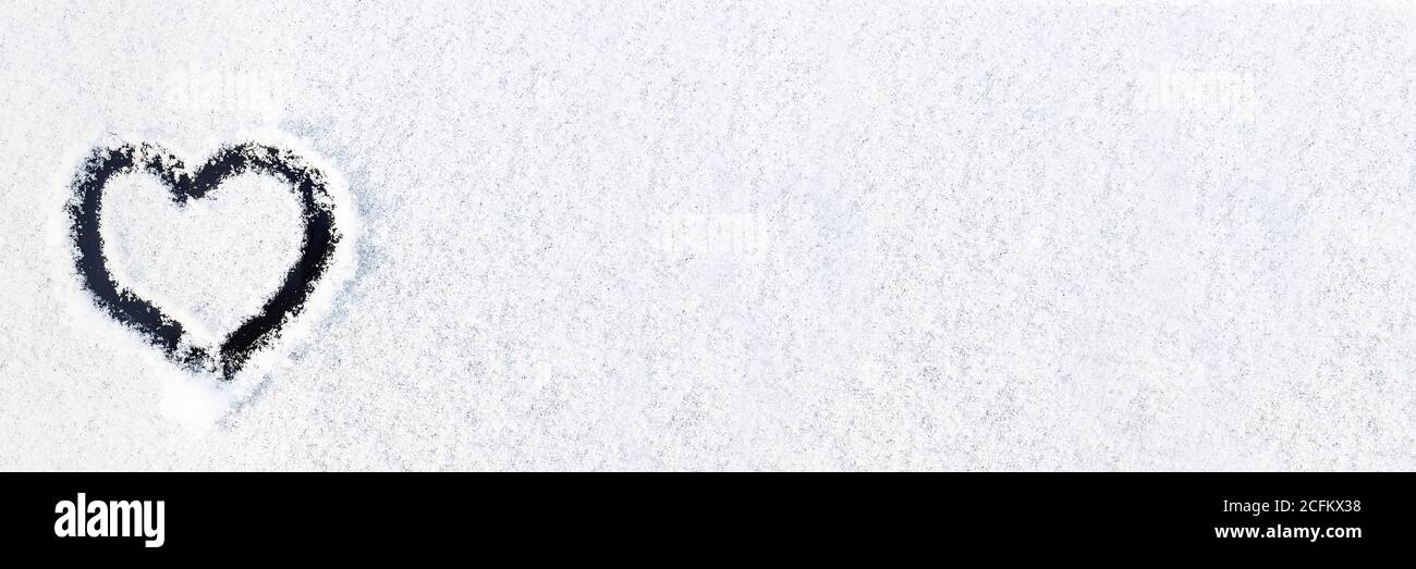 drawn heart on the texture of the snow, the backdrop of snow and a ...