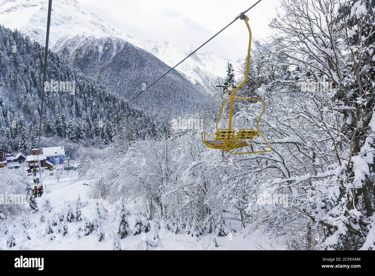Dombai, Karachay-Cherkessia Republic, Russia-December 15, 2018: People go on the old two-seat cable car (second stage) to the ski slopes. Top view of Stock Photo
