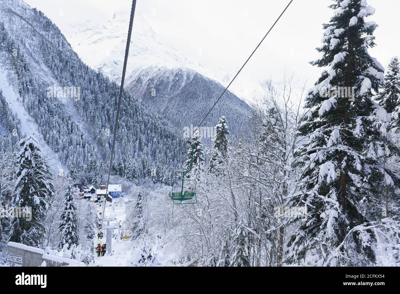 Dombai, Karachay-Cherkessia Republic, Russia-December 15, 2018: People go on the old two-seat cable car (second stage) to the ski slopes. Top view of Stock Photo