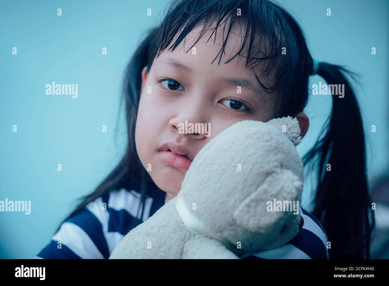 Asian little child girl hugging teddy bear with lonely and sadness Stock Photo