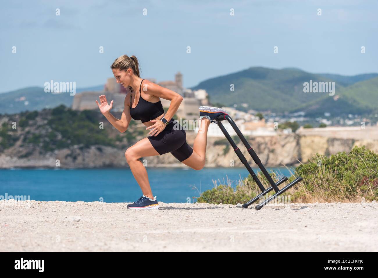 Side view of determined sportsWoman in activewear doing squats during ...