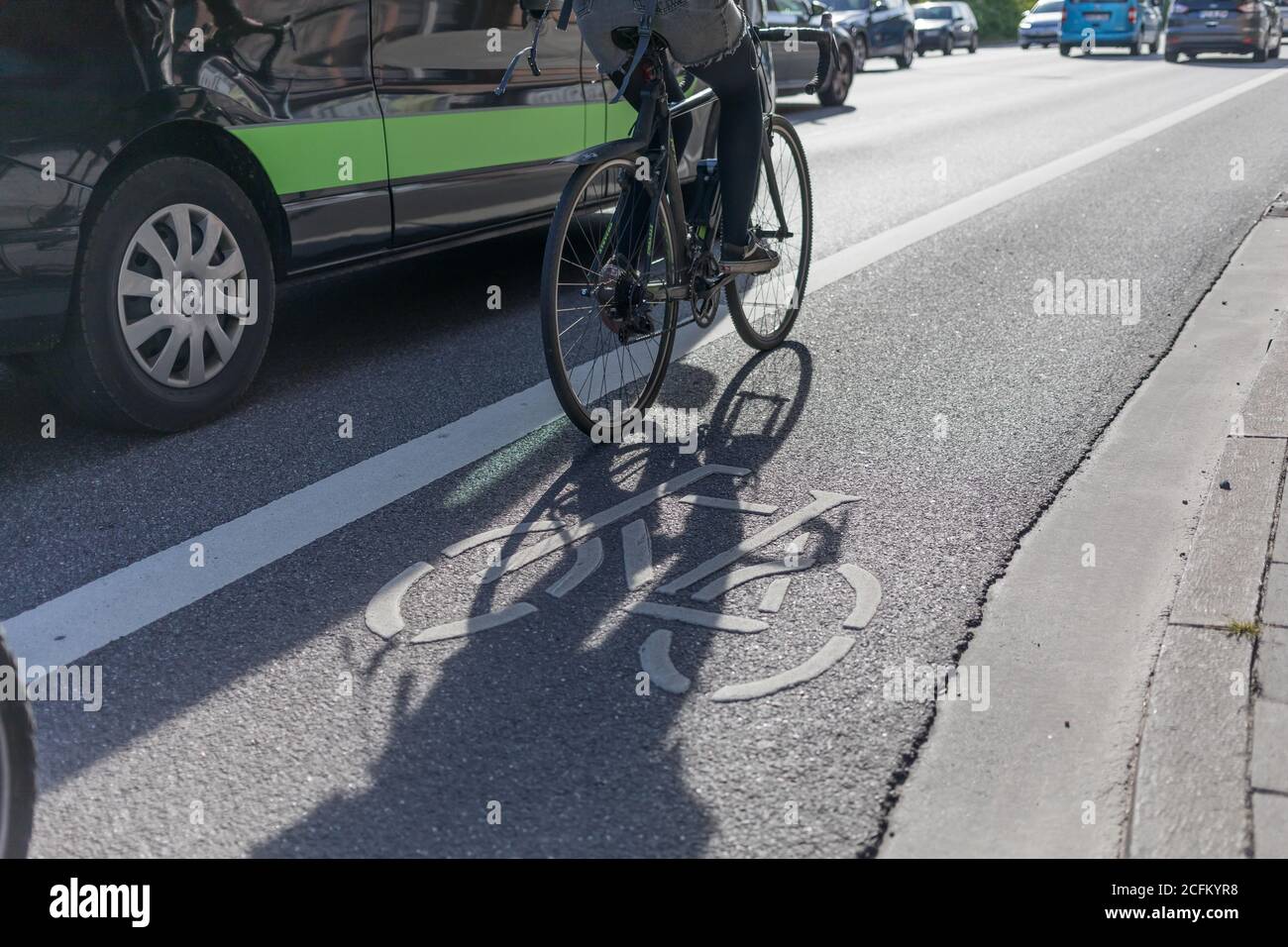 Van ist overtaking cyclist on painted bike lane Stock Photo