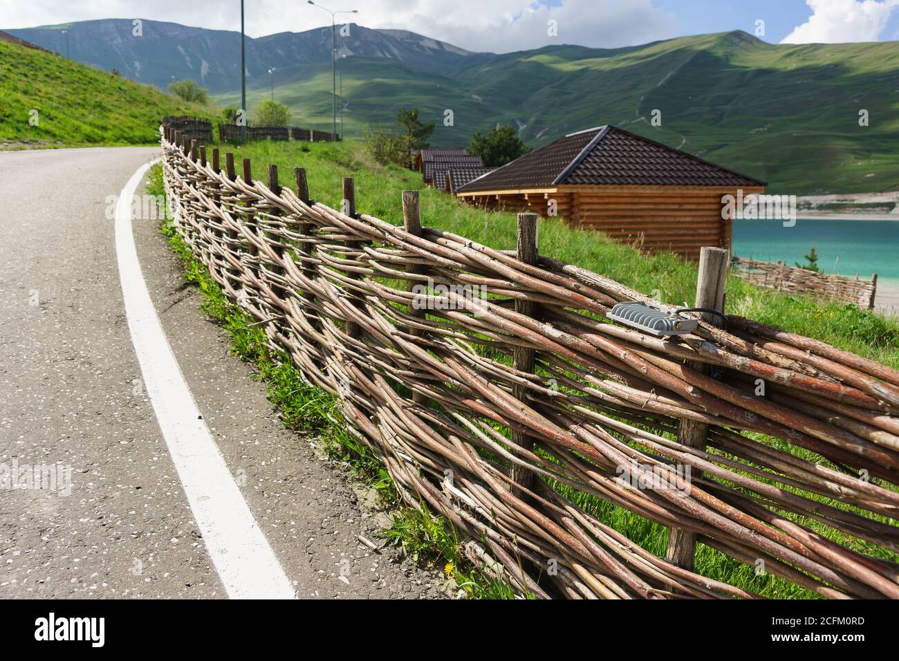 Vedensky district, Chechen Republic, Russia - June 01, 2019: The original fence along the road of woven long branches. Ethnic decoration Stock Photo