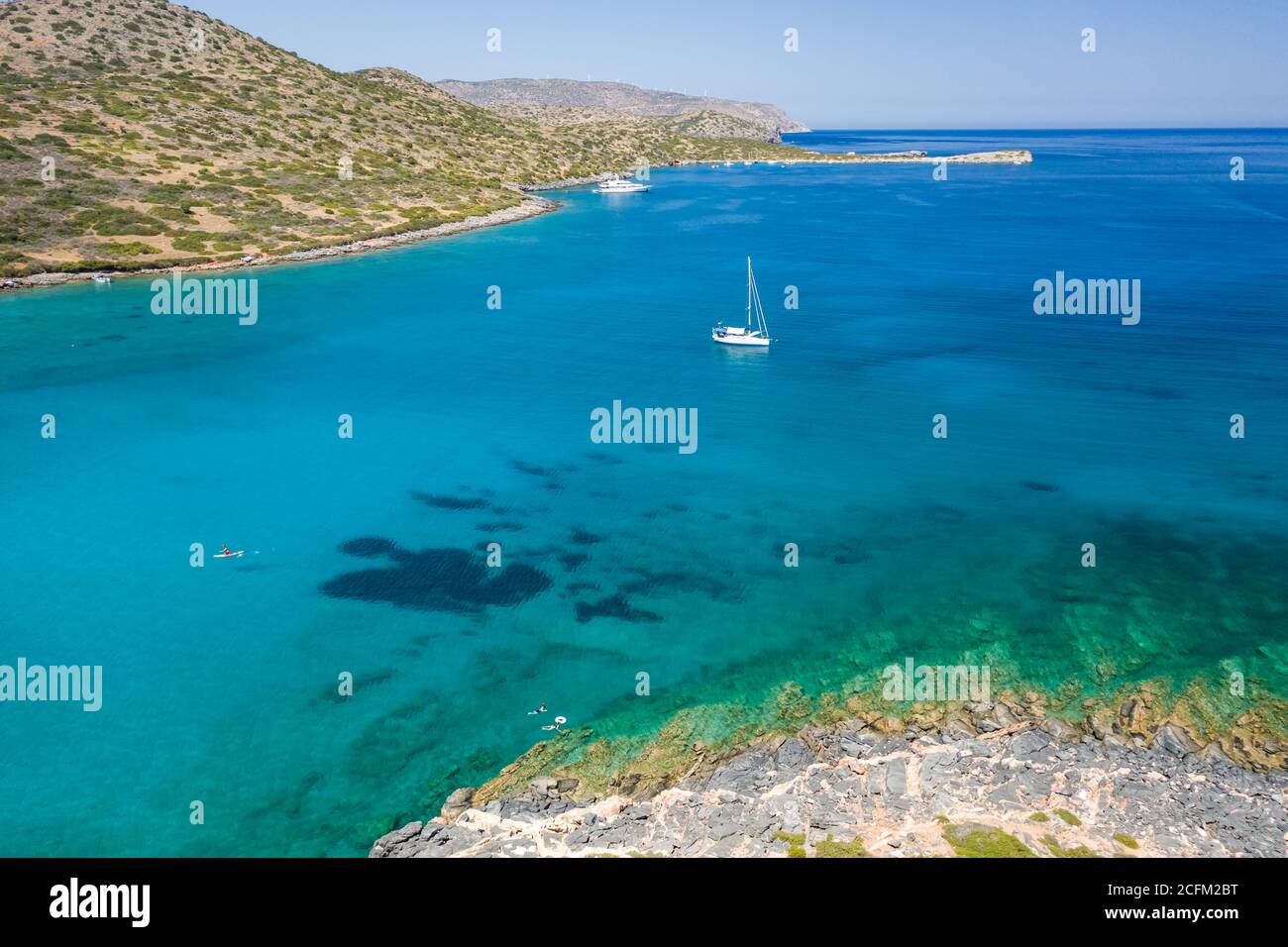 Sailing boats and yachts in the crystal clear waters of the Aegean Sea (Crete, Greece) Stock Photo