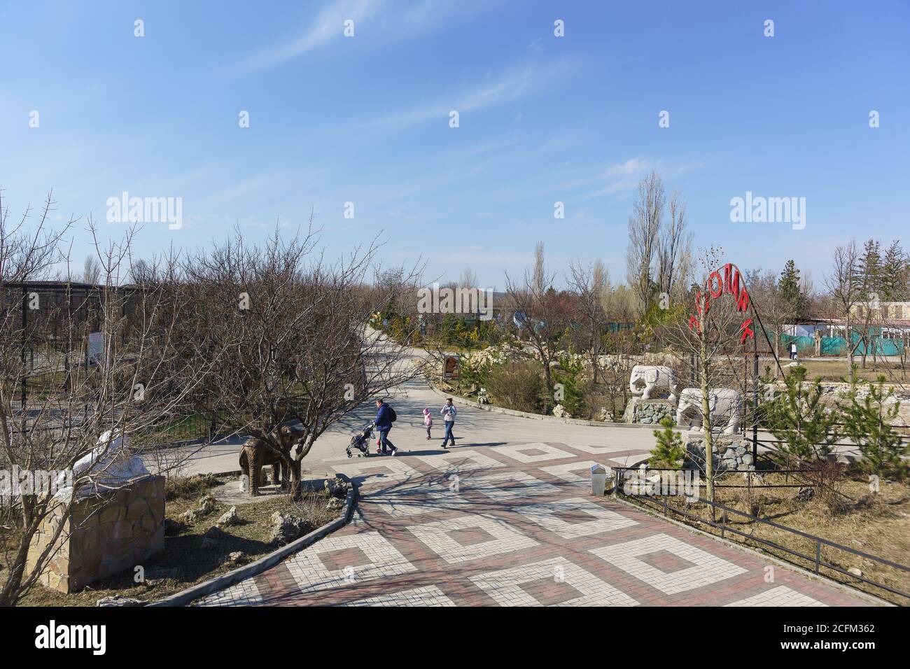 Belogorsk, Crimea, Russia-March 10, 2019: People with children walk on the territory of the Lviv Taigan Safari Park. A cloudy day in early spring. Rus Stock Photo