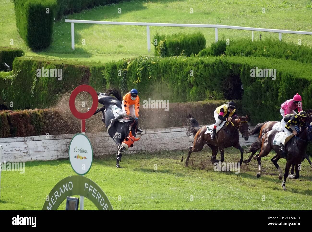 A jockey falling from a horse at the race while others running further at the race in Merano, Italy on Sept. 6th of 2020. Stock Photo