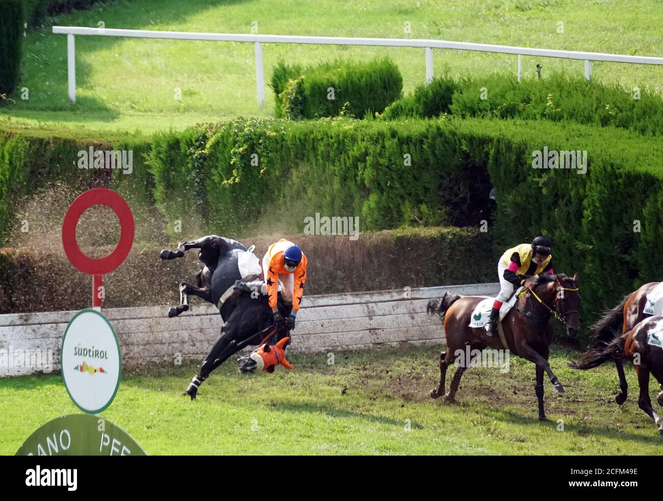 A jockey falling from a horse at the race while others running further at the race in Merano, Italy on Sept. 6th of 2020. Stock Photo