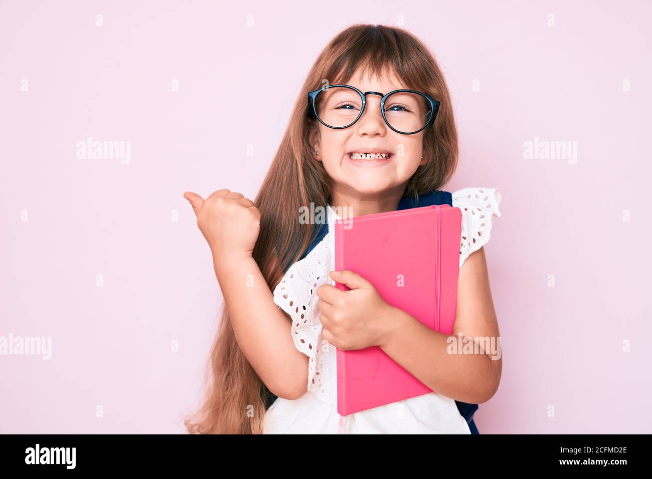 Little caucasian kid girl with long hair wearing student backpack and ...