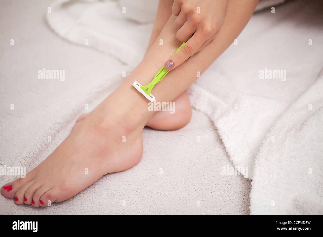 Woman using razor on her beautiful legs Stock Photo Alamy