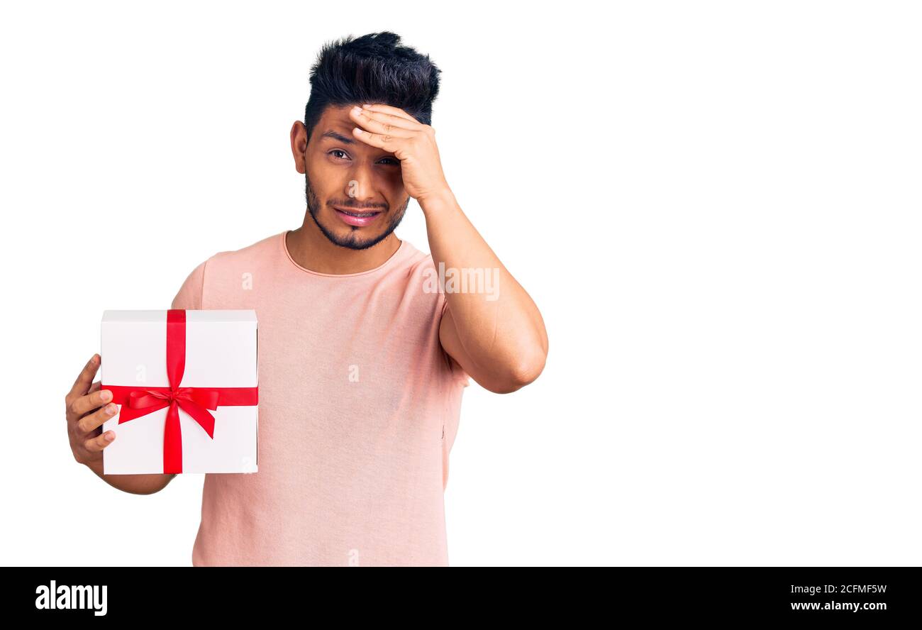 Man Raging Out Gift Handsome latin american young man holding gift stressed and frustrated ...