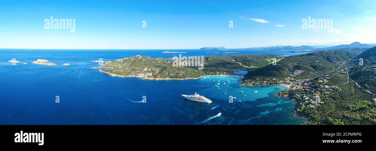 View from above, stunning panoramic view of the Grande Pevero beach with boats and luxury yachts sailing on a turquoise, clear water. Sardinia, Italy. Stock Photo