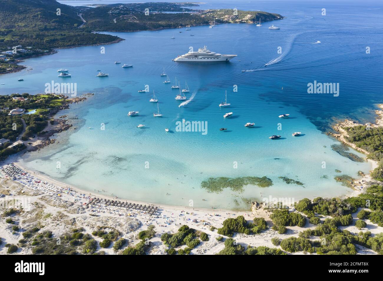 View from above, stunning aerial view of the Grande Pevero beach with boats and luxury yachts sailing on a turquoise, clear water. Sardinia, Italy. Stock Photo