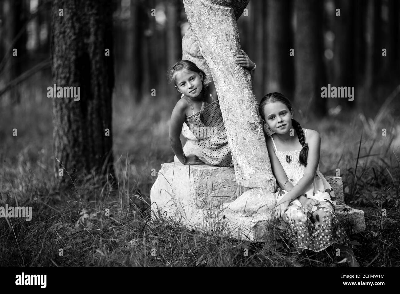 Two ten-year-old girls pose for a photo in the park. Childhood. Black and white photo. Stock Photo