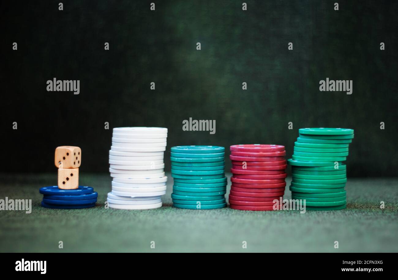 Casino poker chips stack dice on green felt background Stock Photo