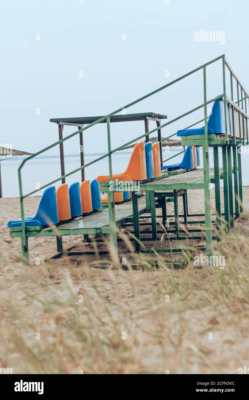 Empty stadium yellow and blue seats at the beach. Lockdown, end of Summer Stock Photo