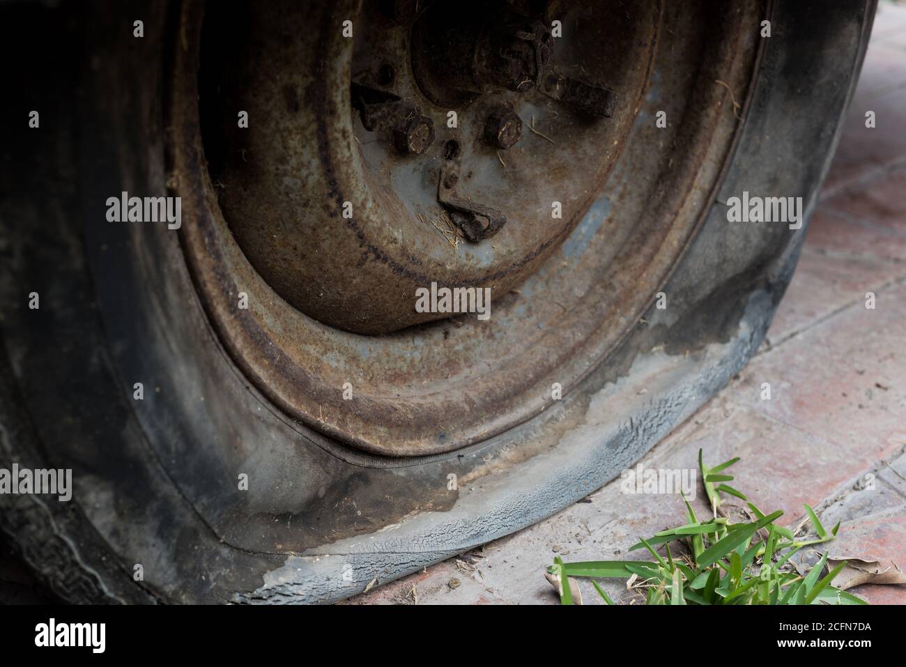 Close up of an abandoned car, rusting wheel with a flat tyre. Stock Photo