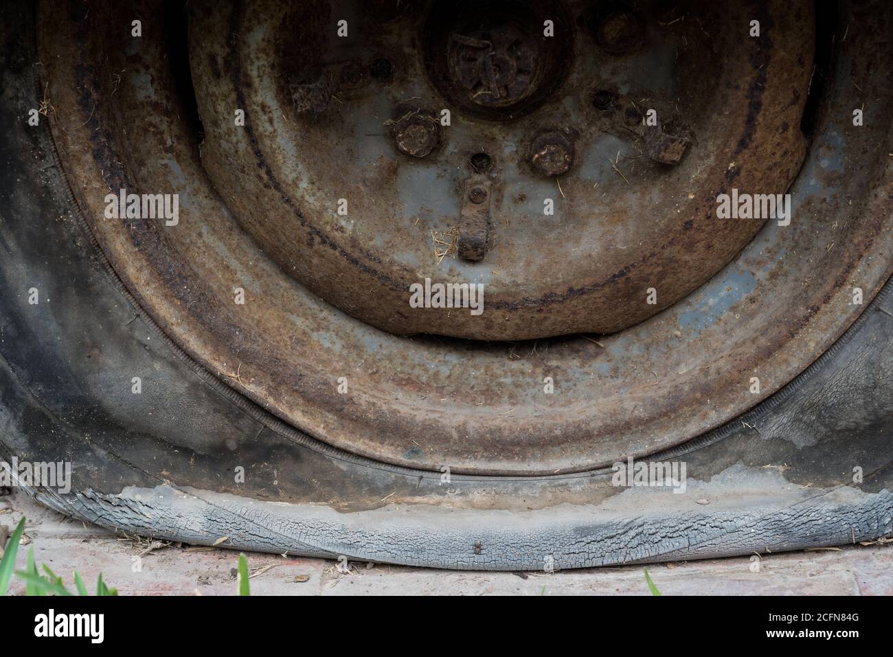 Close up of an abandoned car, rusting wheel with a flat tyre. Stock Photo