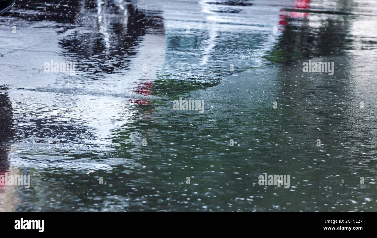 heavy rain in the city. raindrops and water circles on flooded road during downpour Stock Photo