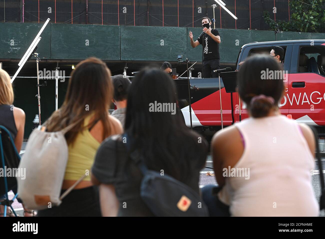 Members of the New York Philharmonic, Countertenor and Producer Anthony Ross Constanzo, accompanied orchestra members violinist Quan Ge and assistant viola Cong Wu, sings from the flatbed of the “NY Phil Bandwagon” pickup truck in front of a gathered crowd at The Lot Radio in the Brooklyn borough of New York, NY, September 6, 2020. With music venues still closed due to COVID-19 pandemic restrictions, the New York Philharmonic created “pull-up” performance throughout the five New York City boroughs, but does not give any advance notice to minimize crowd size and the risk of spreading the corona Stock Photo