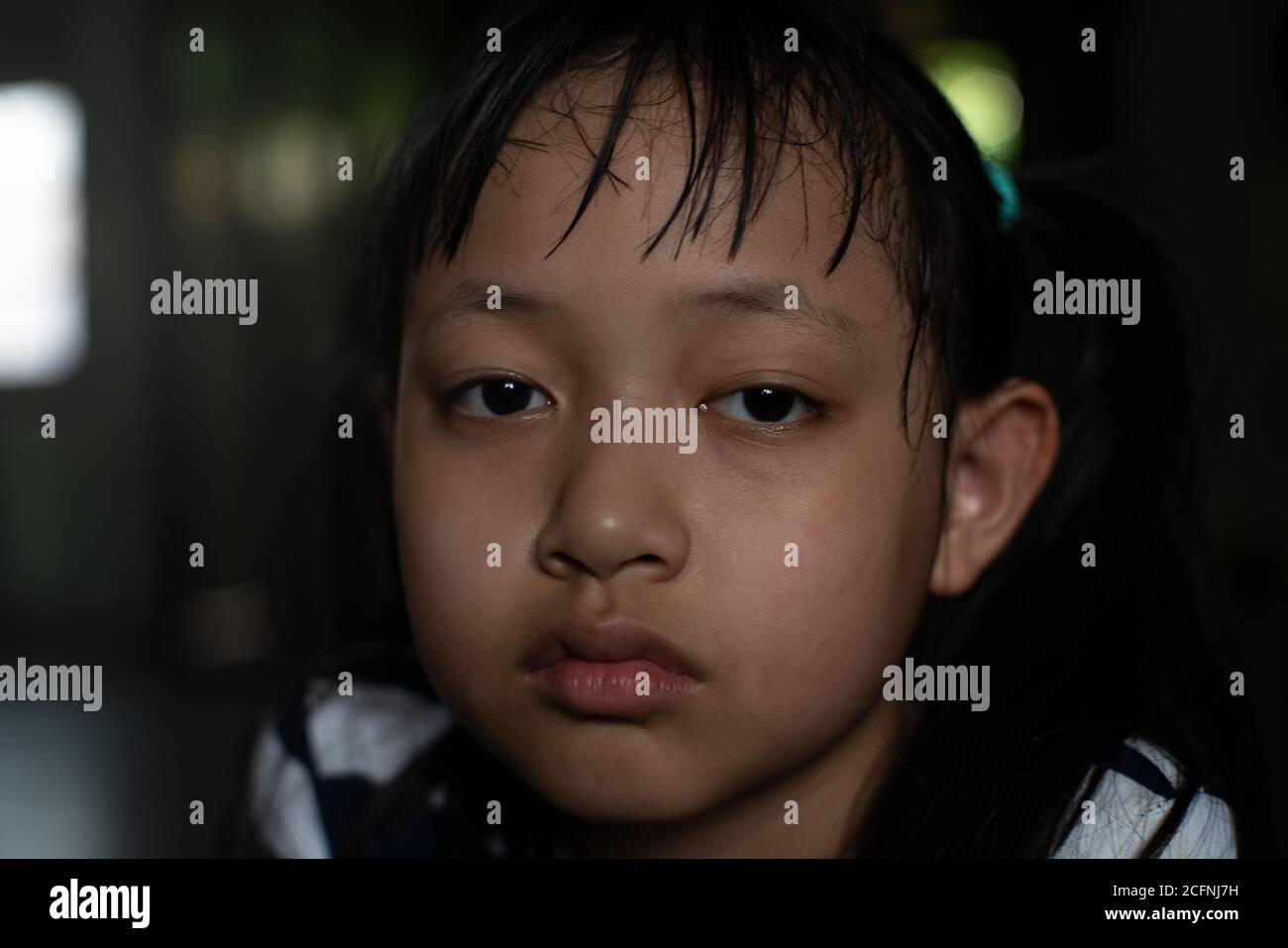 Asian little child girl looking up and thinking with lonely and sadness.Low key style Stock Photo