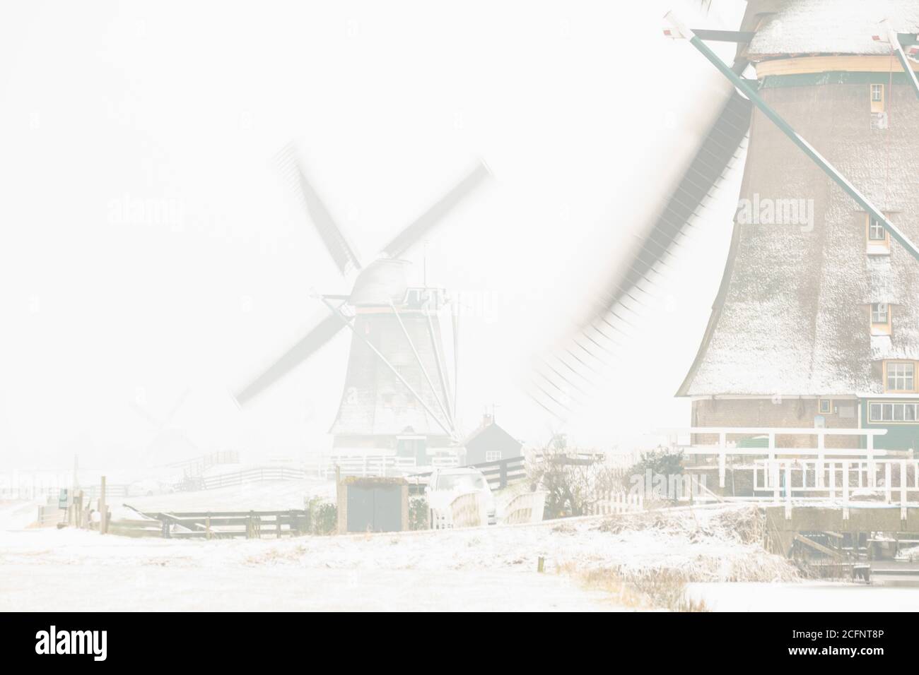 The Netherlands, Aarlanderveen, Windmills in snow. Winter. High key. Stock Photo