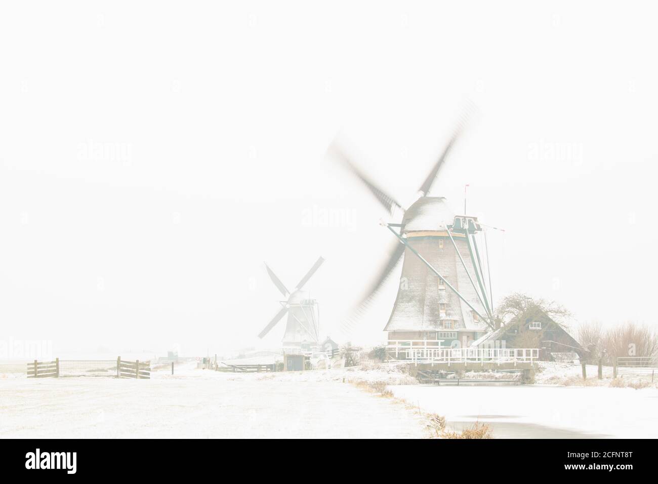 The Netherlands, Aarlanderveen, Windmills in snow. Winter. High key. Stock Photo