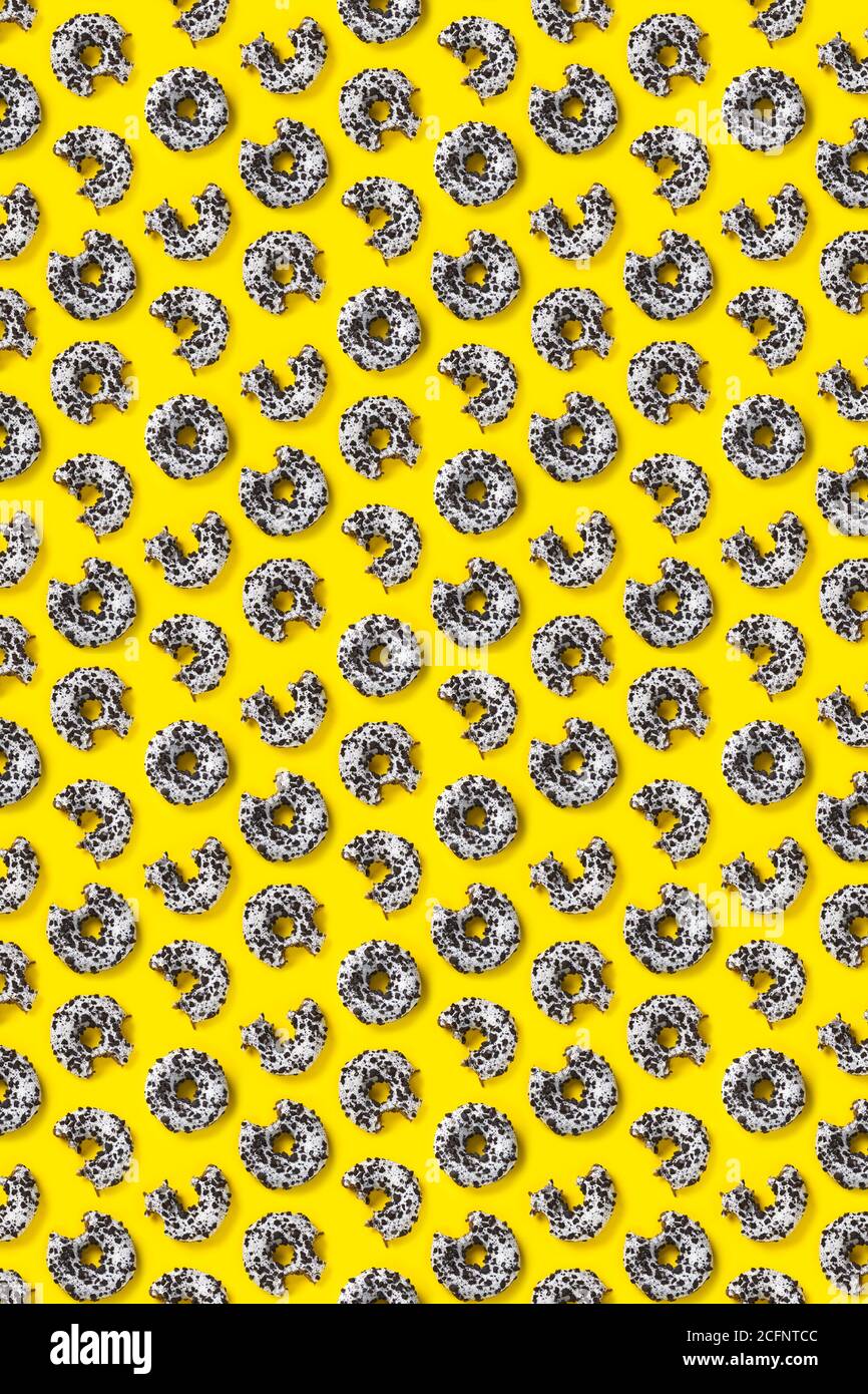 donuts on a yellow background top view. Flat lay of delicious nibbled ...