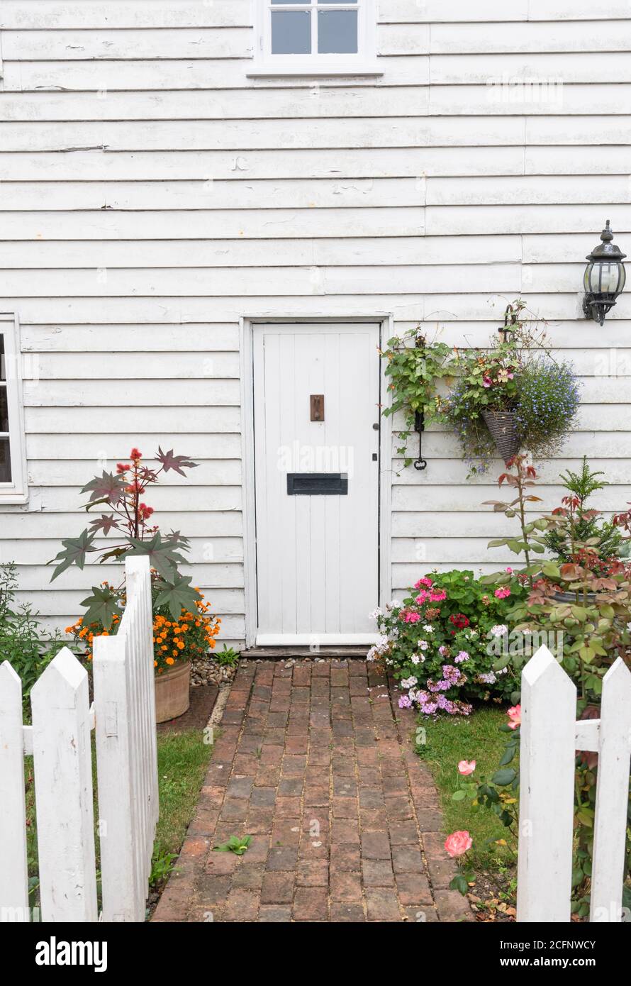 The front door in a white weather boarded cottage. Stock Photo