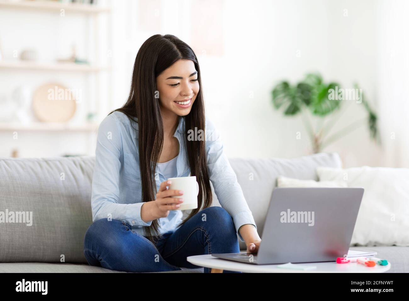 smiling-asian-girl-unwinding-with-laptop