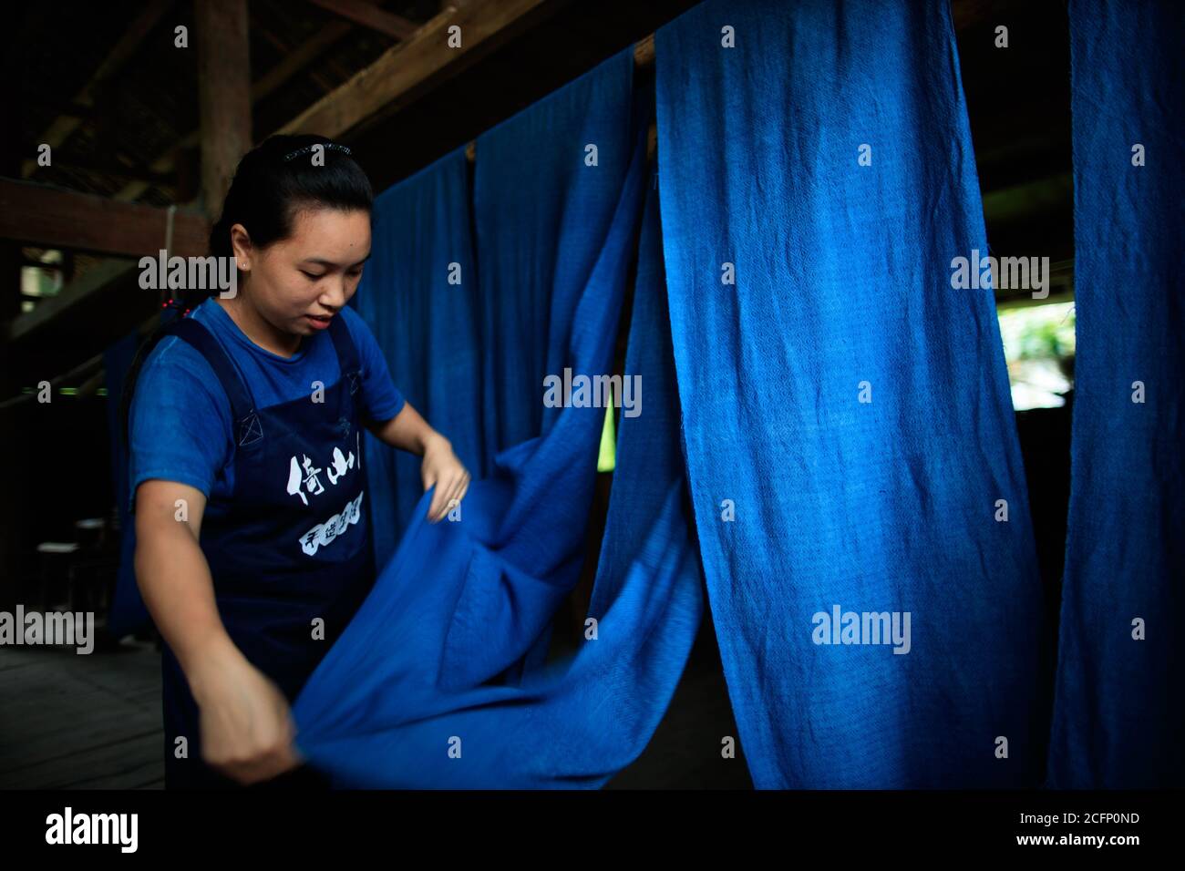 Rongjiang, China's Guizhou Province. 6th Sep, 2020. A woman hangs cloth at a workshop in Fengdeng Dong Village of Rongjiang County, southwest China's Guizhou Province, Sept. 6, 2020. Locals take advantage of the favorable autumn weather conditions to make the traditional cloth of Dong ethnic group. Credit: Liu Xu/Xinhua/Alamy Live News Stock Photo