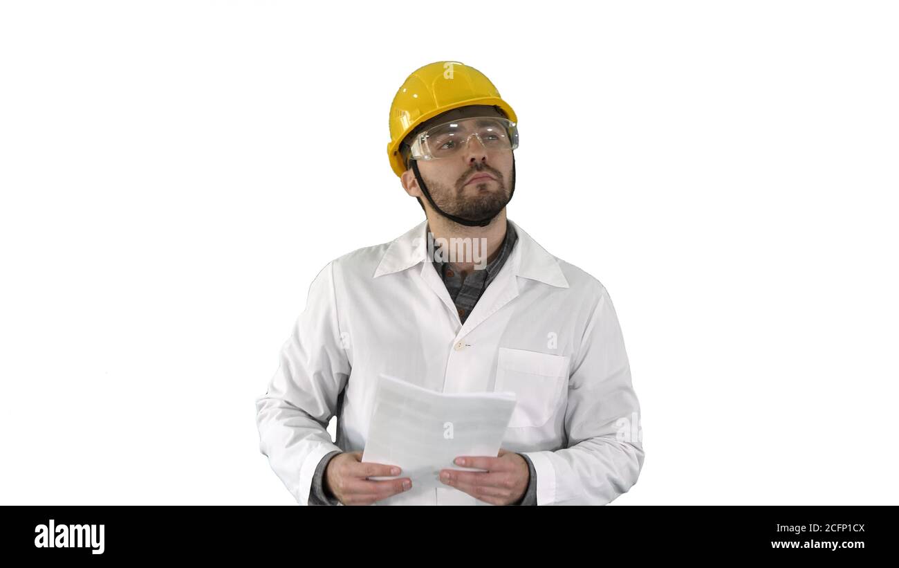 Site engineer cheching papers and something around him on white background. Stock Photo
